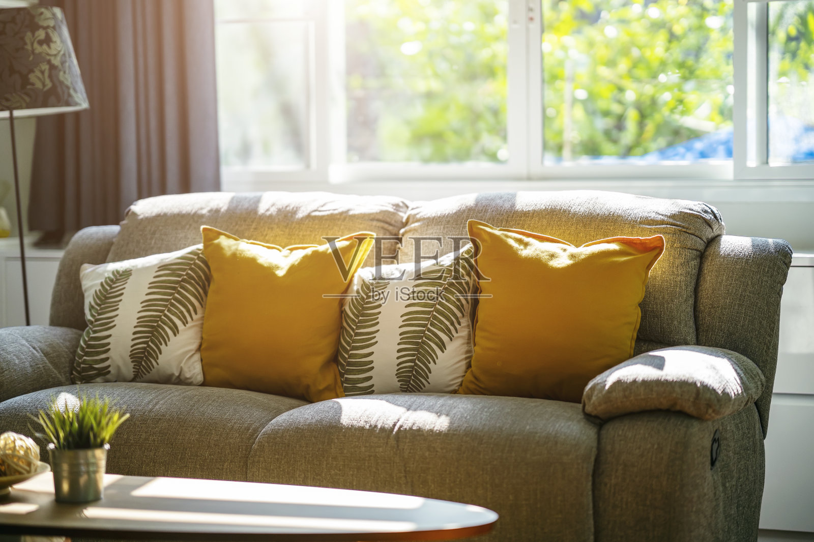 老式沙发和枕头在客厅，早上有阳光。放松的角落的概念。照片摄影图片