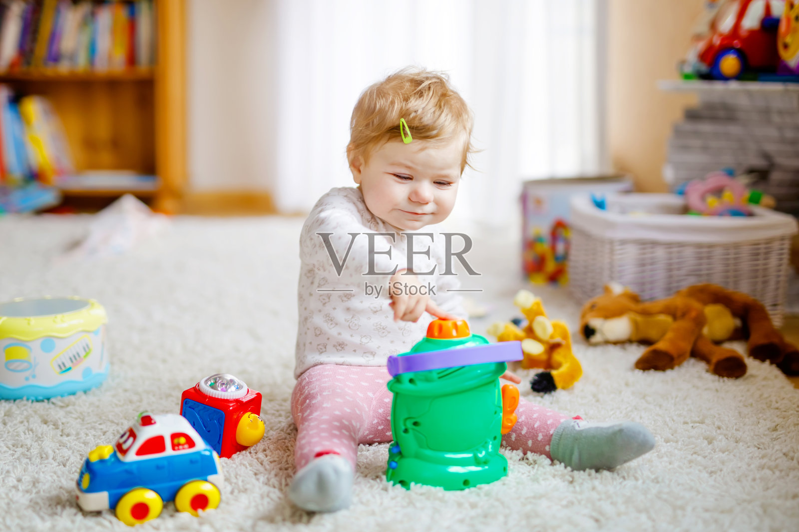 快乐快乐的小女孩在家里玩着各种五颜六色的玩具。可爱的健康蹒跚学步的孩子玩得很开心。活跃的室内休闲，托儿所或游戏学校。照片摄影图片