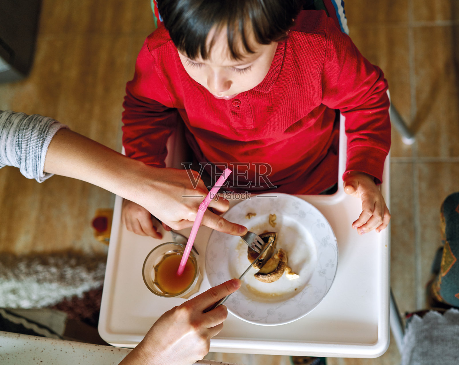 可爱的孩子在餐桌上吃蔬菜和喝果汁。孩子2-3岁。照片摄影图片