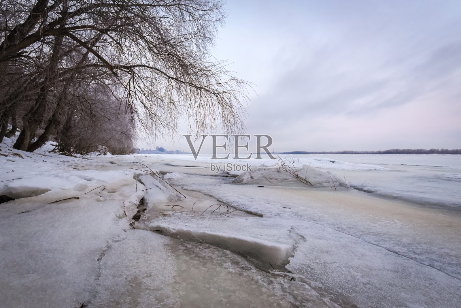 冬天的景色在黎明时分，河堤上结了一层冰。照片摄影图片