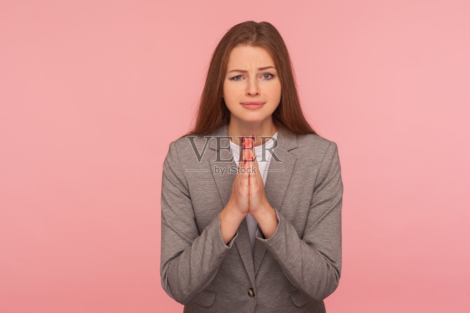 拜托，我需要帮助!恳求的年轻女子的肖像在商务套装祈祷，乞求与顽皮和恳求鬼脸照片摄影图片