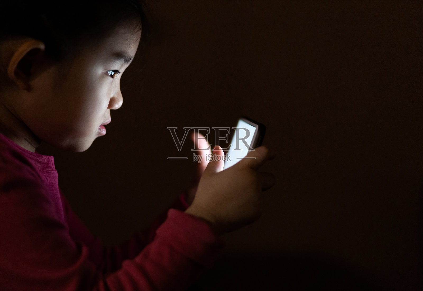 小女孩在黑暗中使用智能手机照片摄影图片