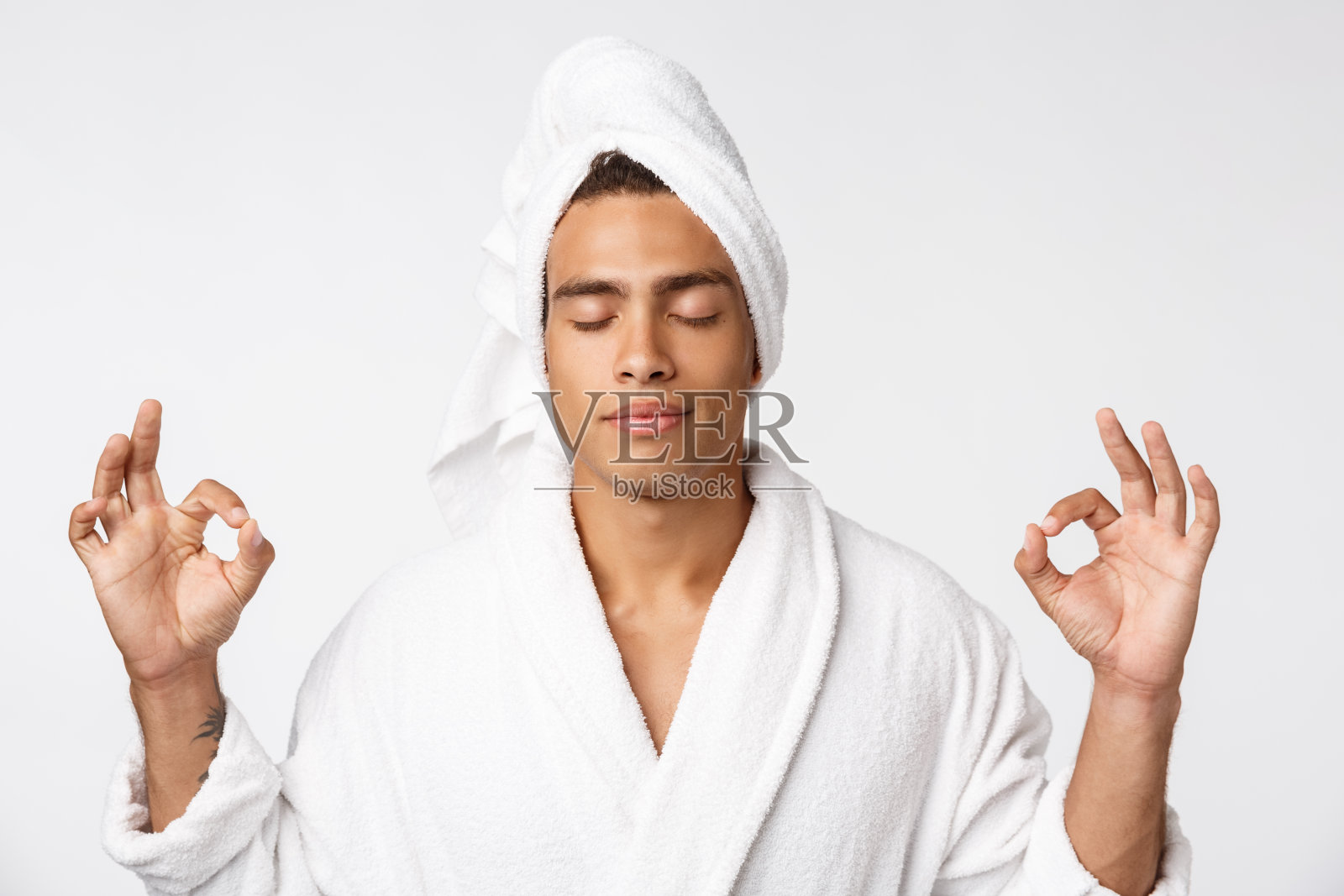 集中的非洲人在莲花位置裁剪。闭着眼睛冥想。男性在浴衣和毛巾孤立在白色背景照片摄影图片