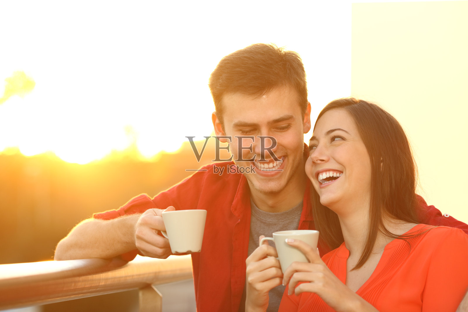 一对幸福的夫妇在阳台上享受日落咖啡照片摄影图片