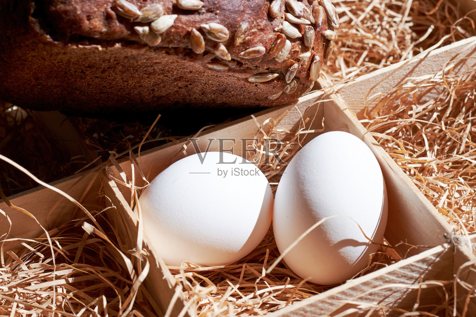 复活节彩蛋和黑色的面包条在方形的食物容器与稻草。传统的区域食品。照片摄影图片