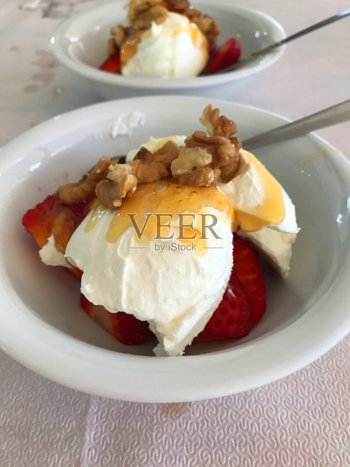 两个希腊甜点，酸奶，草莓，蜂蜜和核桃照片摄影图片