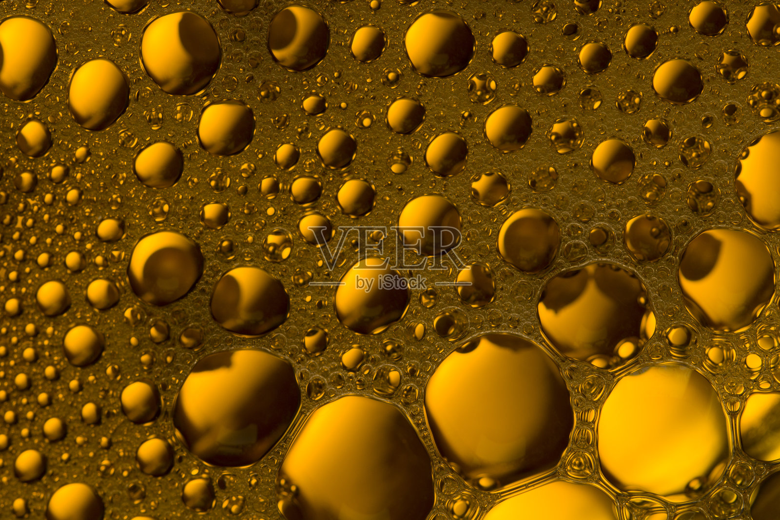 泡沫和水滴在橙色和黄色的液体背景。泡沫纹理照片摄影图片