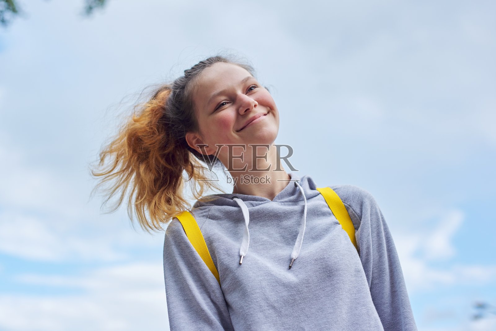 15岁少女的肖像，微笑的漂亮女孩在灰色运动衫照片摄影图片