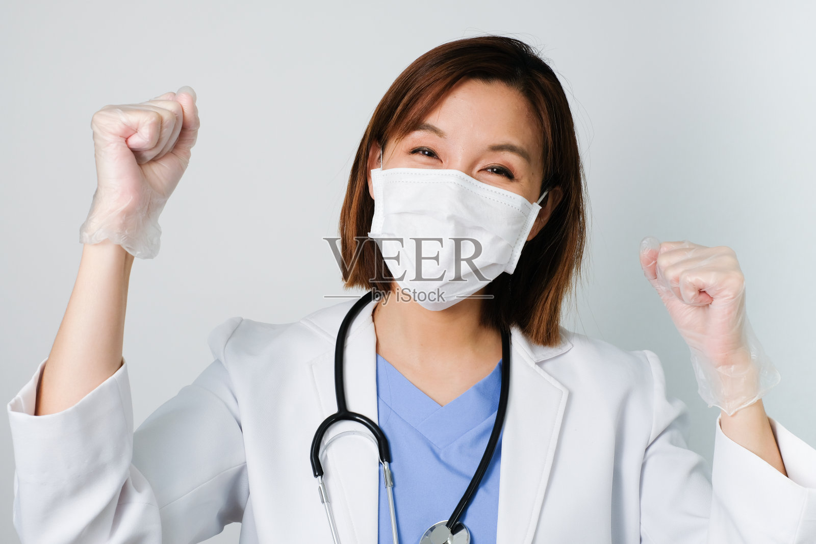 快乐的亚洲医生戴着医用口罩，保护和抵抗细菌、细菌、新型冠状病毒、SARS、流感病毒的感染，白色的背景上带着快乐的脸。照片摄影图片