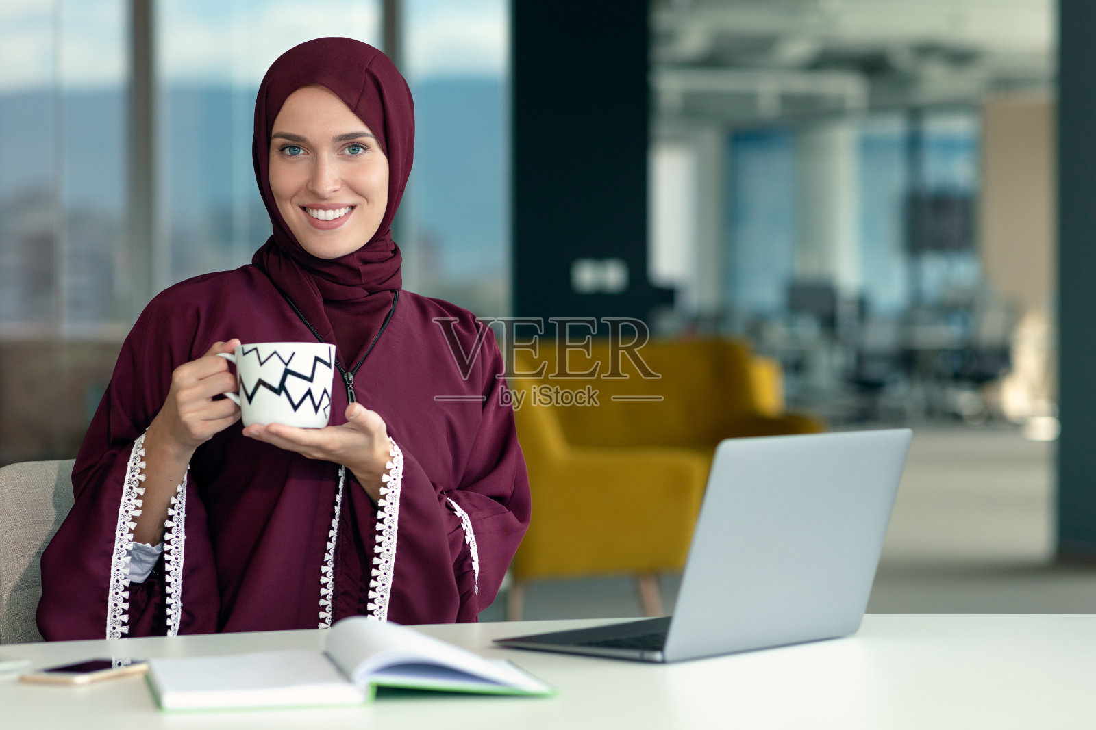 年轻的穆斯林职业女性在工作中使用移动数字平板电脑照片摄影图片