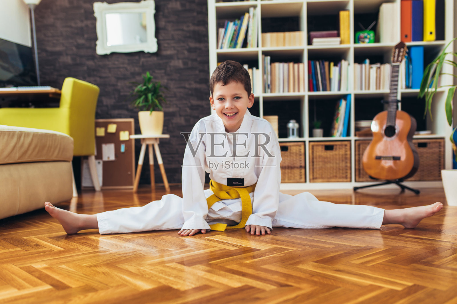 跆拳道男孩在家客厅锻炼。照片摄影图片