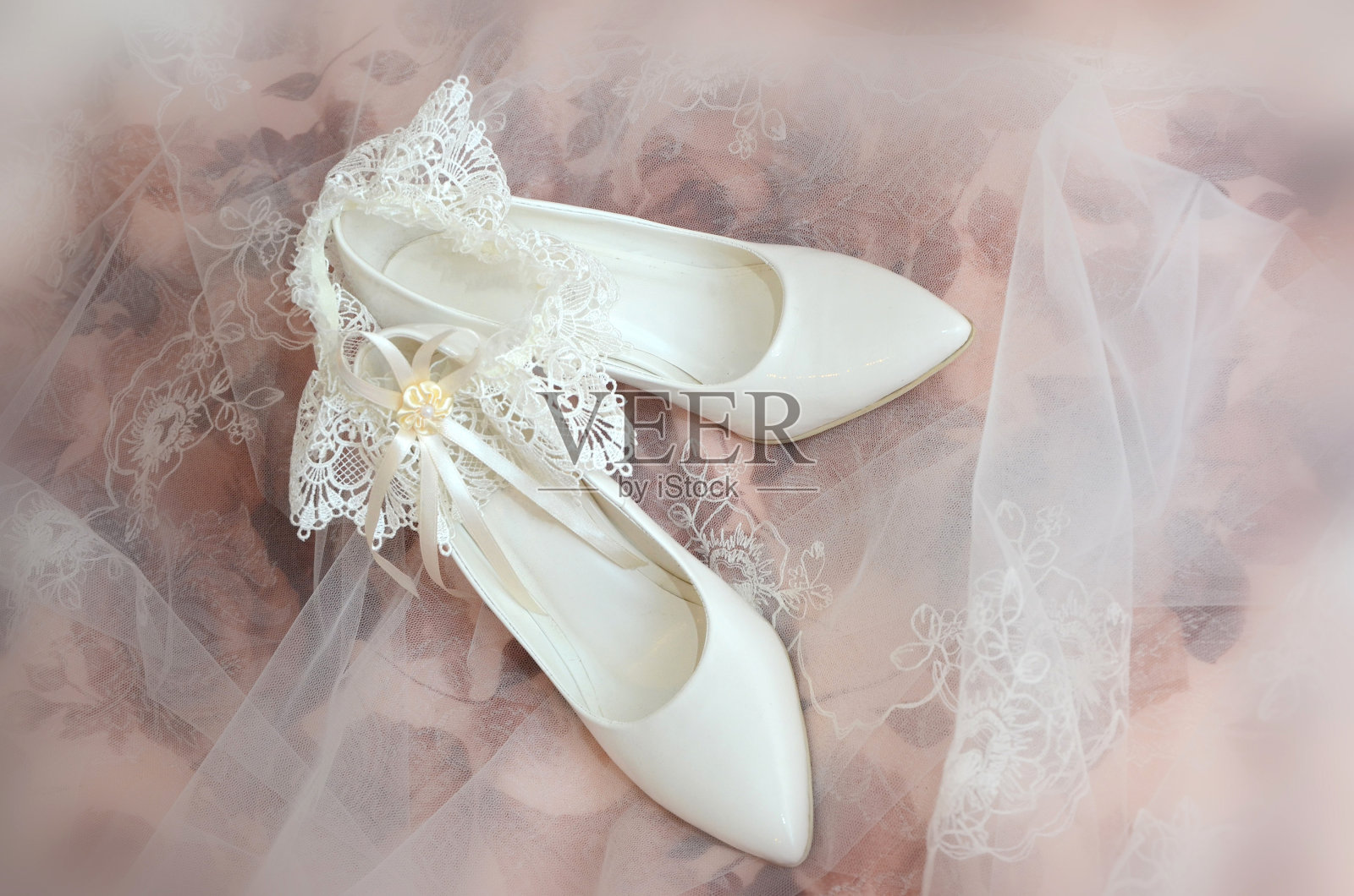 白色的婚礼鞋和新娘的吊袜带在一个模糊的背景照片摄影图片