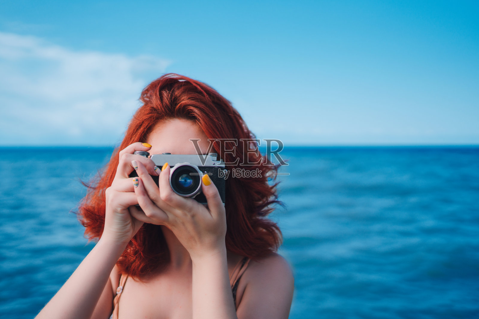 带着相机在海边的人。照片摄影图片