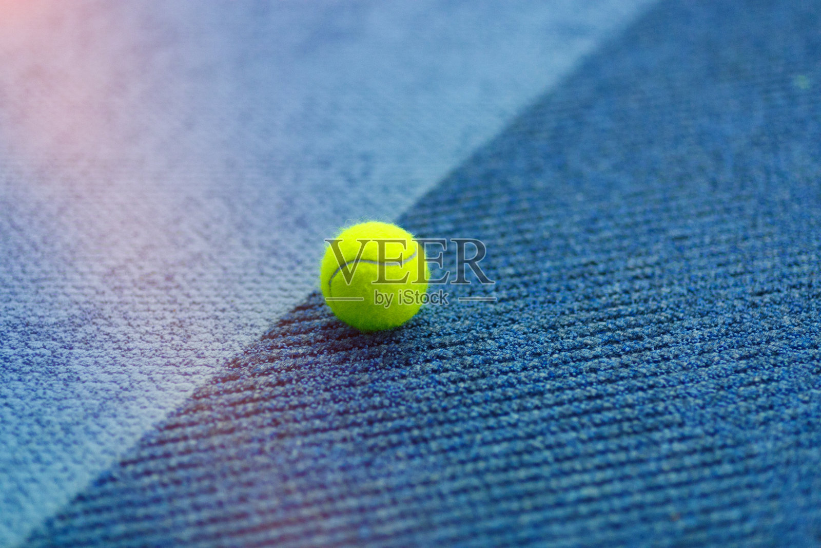 蓝色室内地毯上的网球照片摄影图片