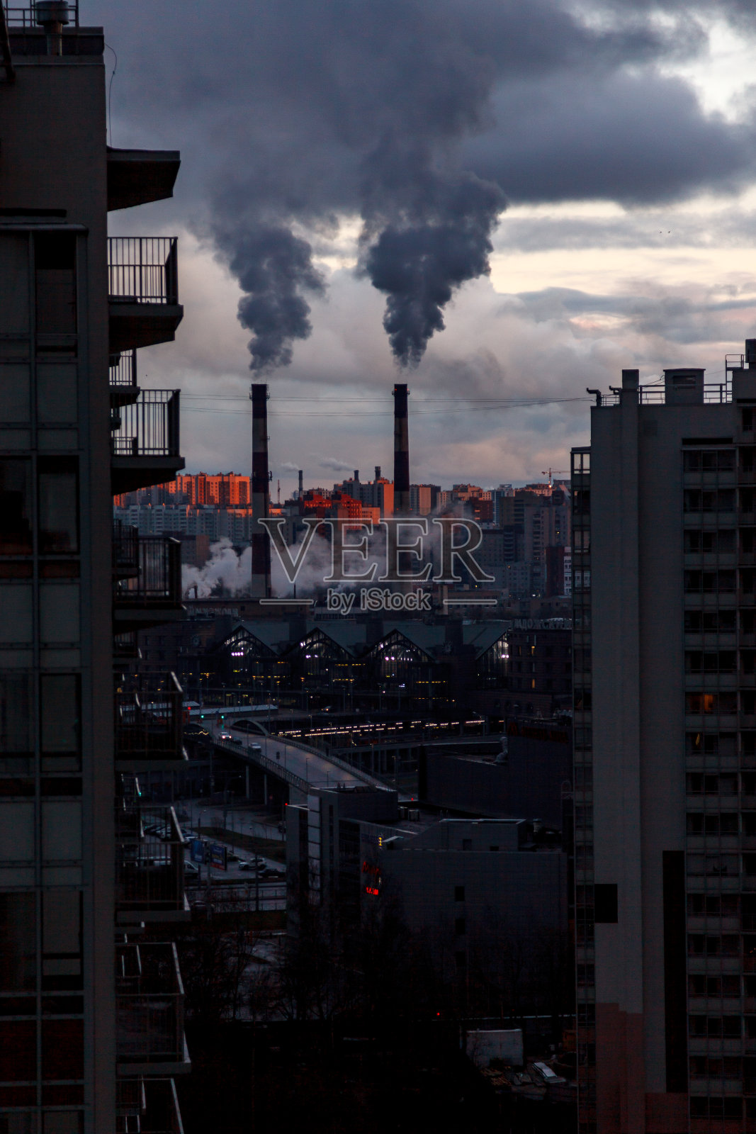 环境与空气污染、生态问题概念。工厂烟囱冒出的烟雾映衬着灰色多云的天空。城市景观。照片摄影图片