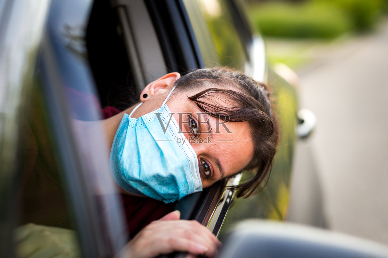 开车时戴防护面罩的女性汽车司机照片摄影图片