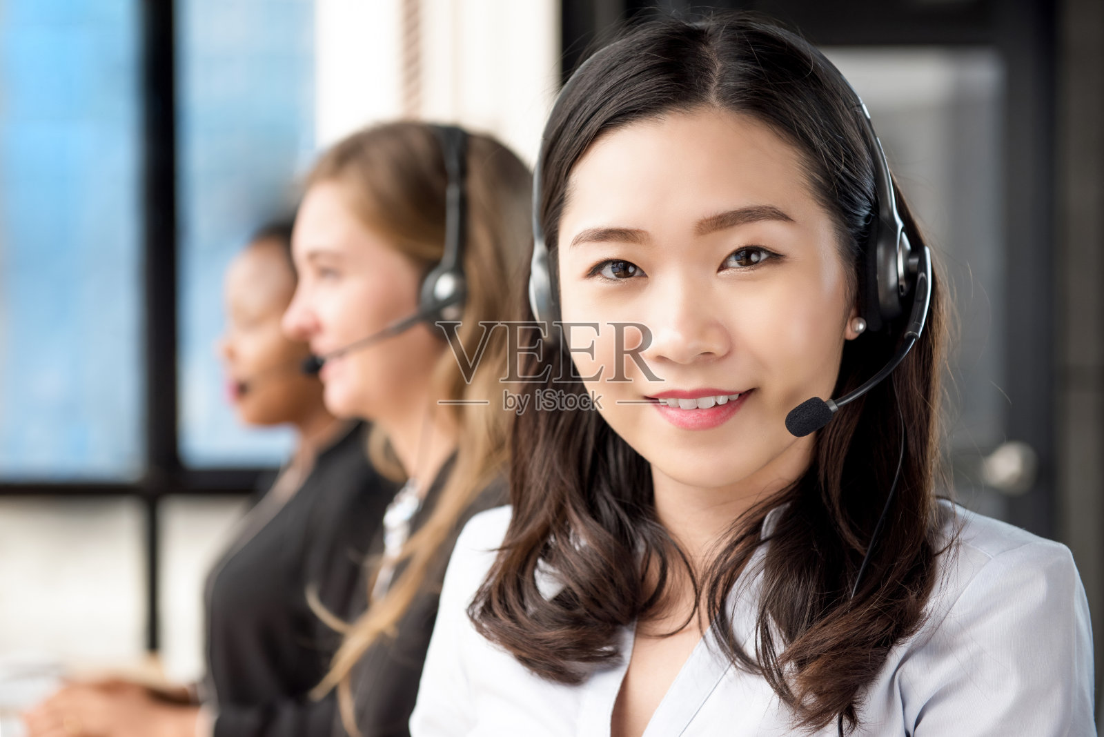 在呼叫中心工作的亚洲女性客户服务人员照片摄影图片