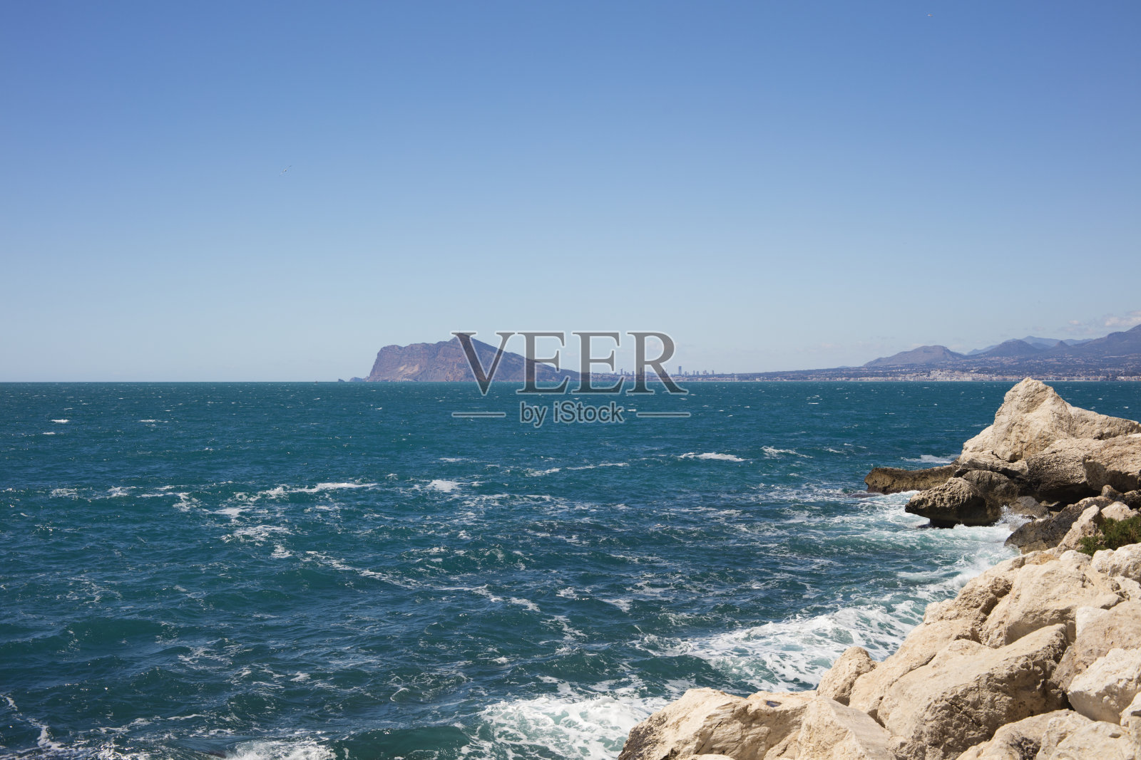 海滩细节与绿松石和蓝色的海与Altea和Benidorm在背景照片摄影图片