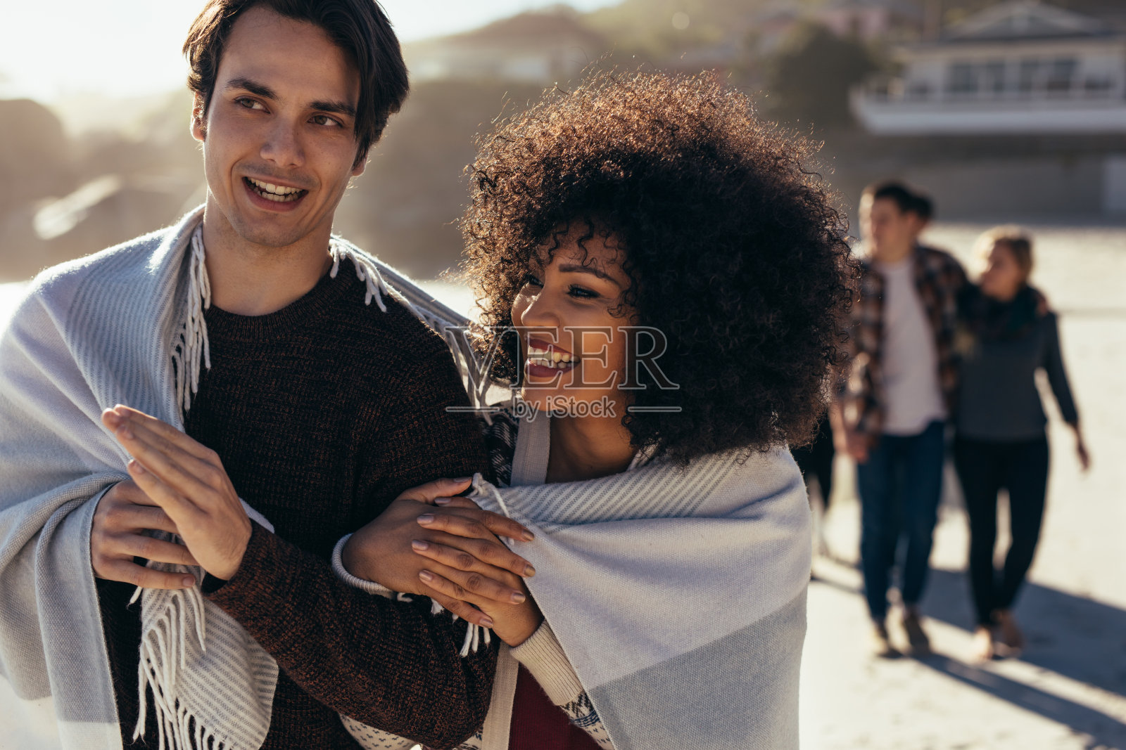 微笑的年轻夫妇在海滩上散步照片摄影图片