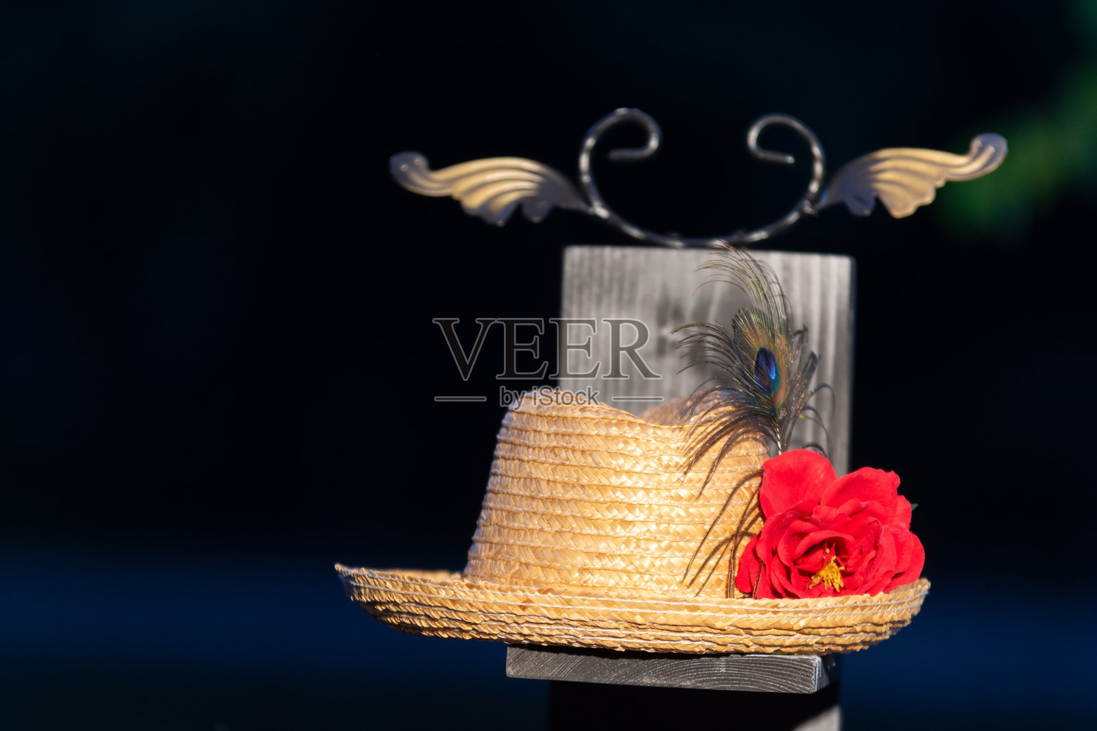草帽立在镶有红玫瑰的木板上照片摄影图片