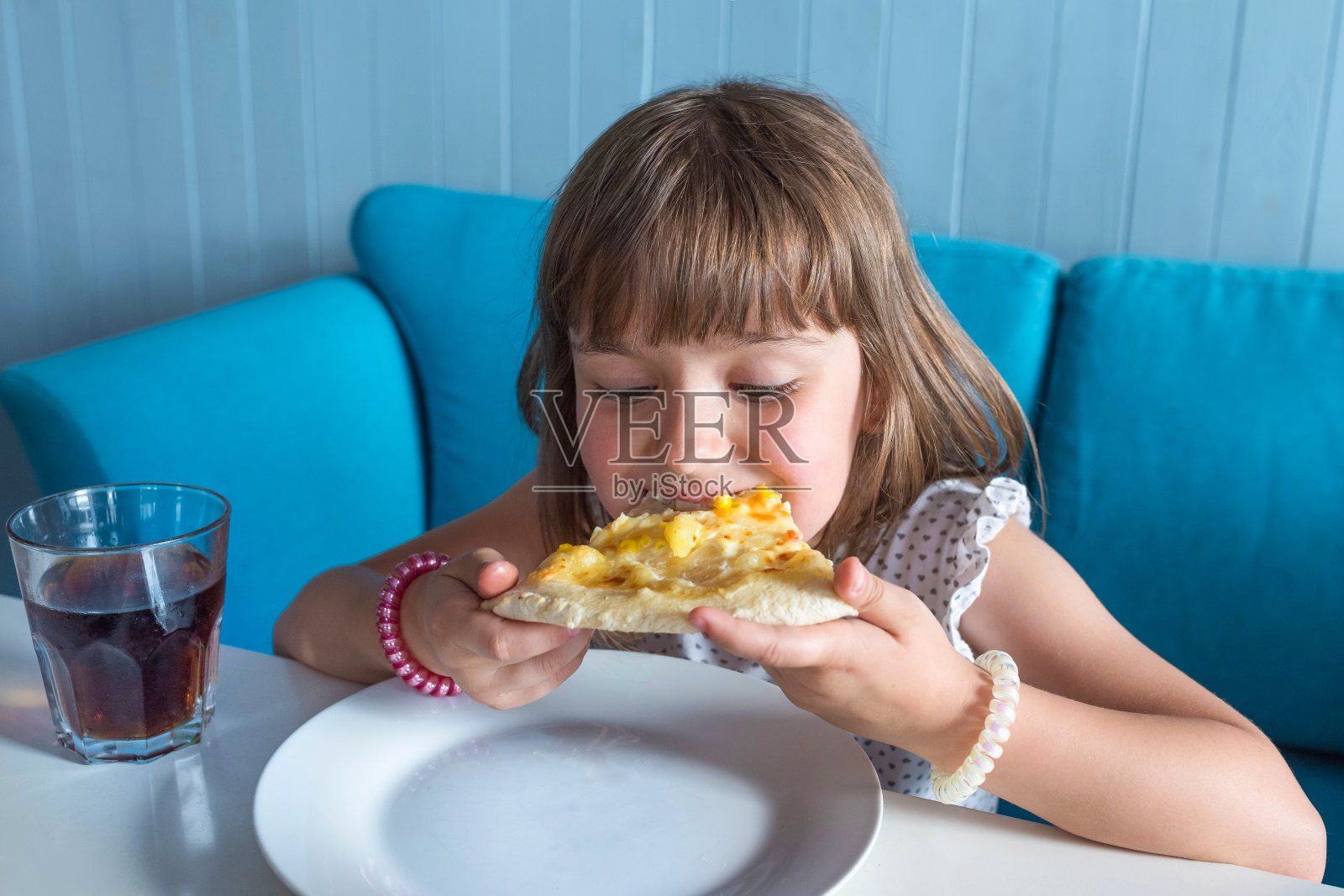 小女孩在餐厅吃热披萨。照片摄影图片