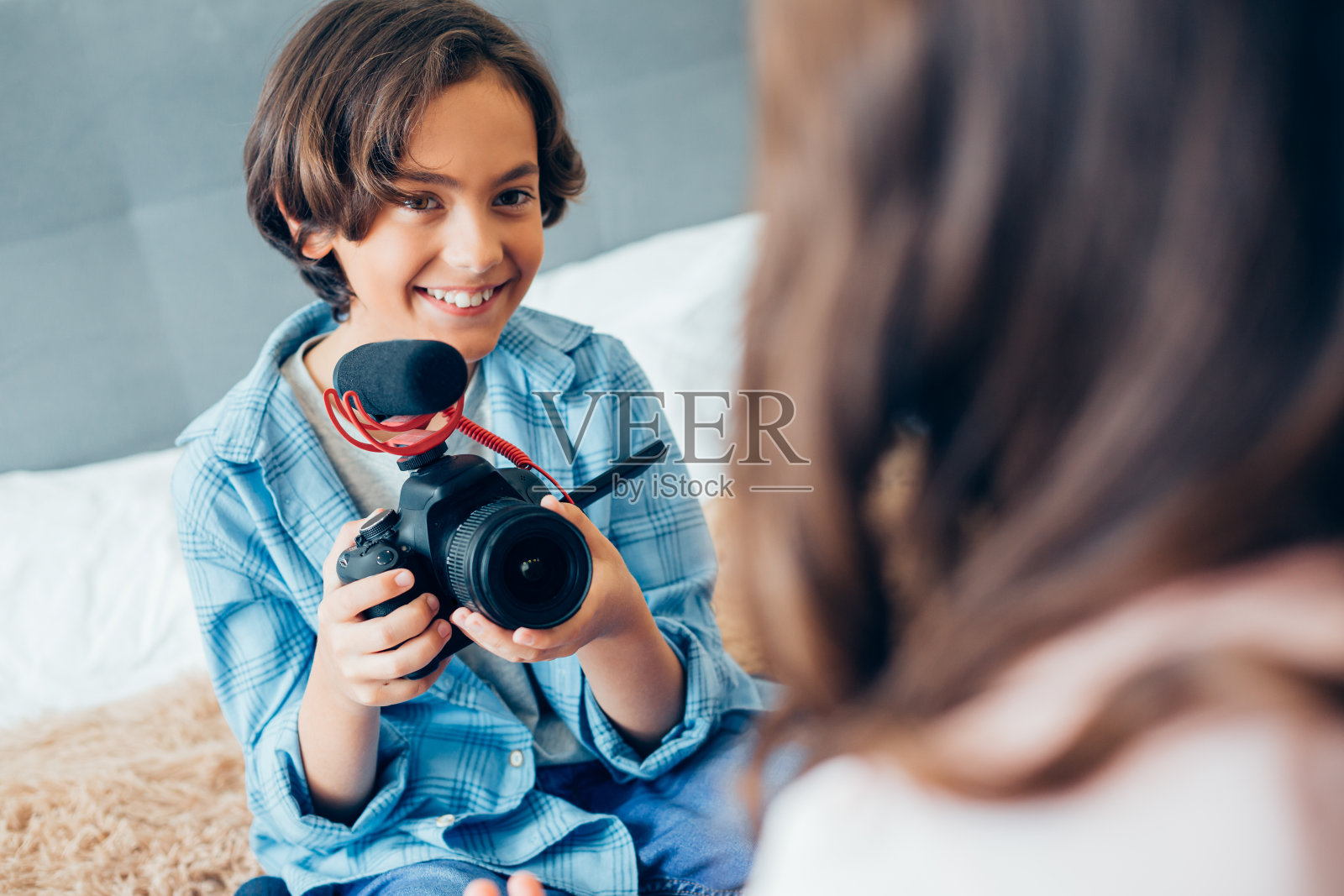 欢乐的男孩拿着相机拍他朋友的视频照片摄影图片