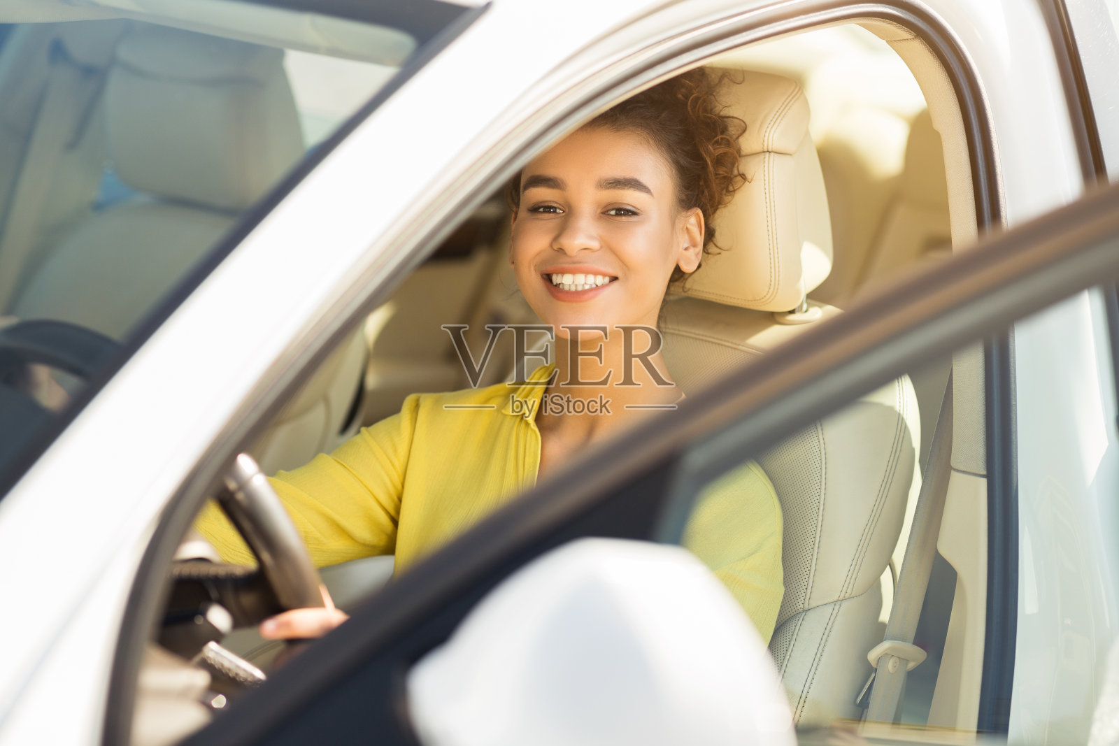 快乐的非洲女孩坐在自动学习开车照片摄影图片
