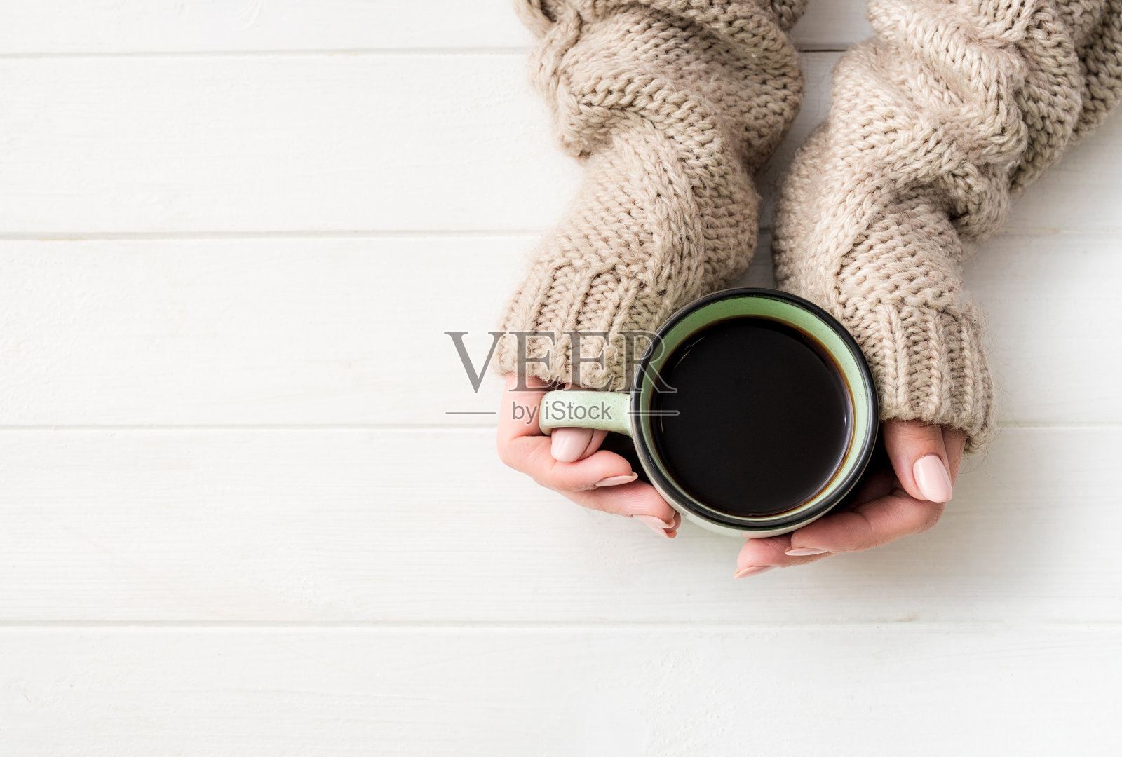 俯视图的女孩在毛衣拿着咖啡杯照片摄影图片