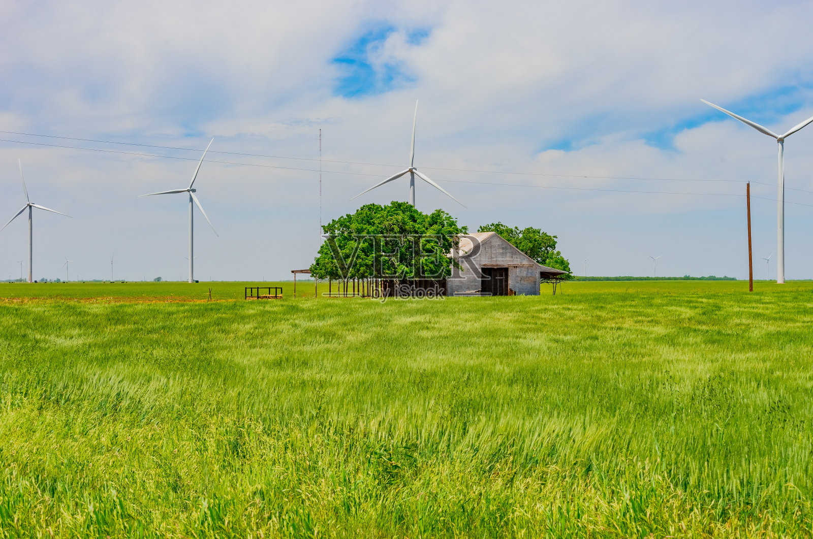 风力涡轮机和德州平原上的一个旧谷仓照片摄影图片