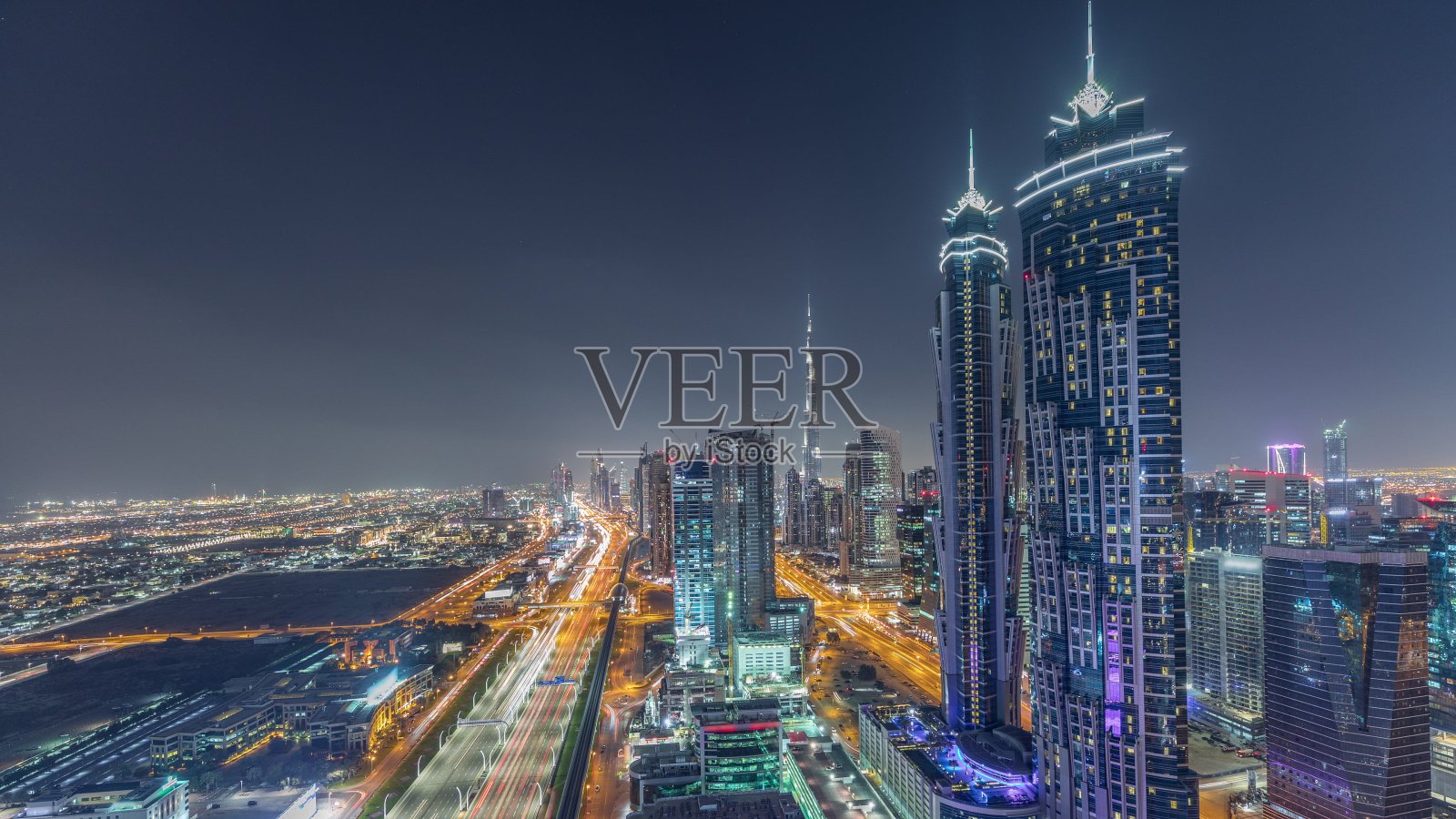 在阿联酋迪拜，夜晚的天际线与现代摩天大楼和交通在谢赫扎耶德路的时间流逝照片摄影图片