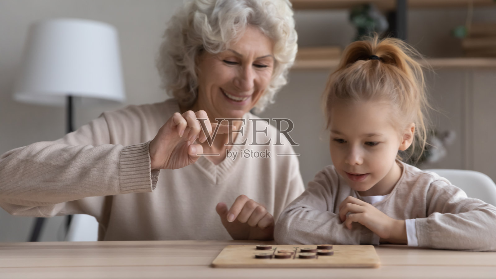 快乐成熟的奶奶和小孙女下棋照片摄影图片