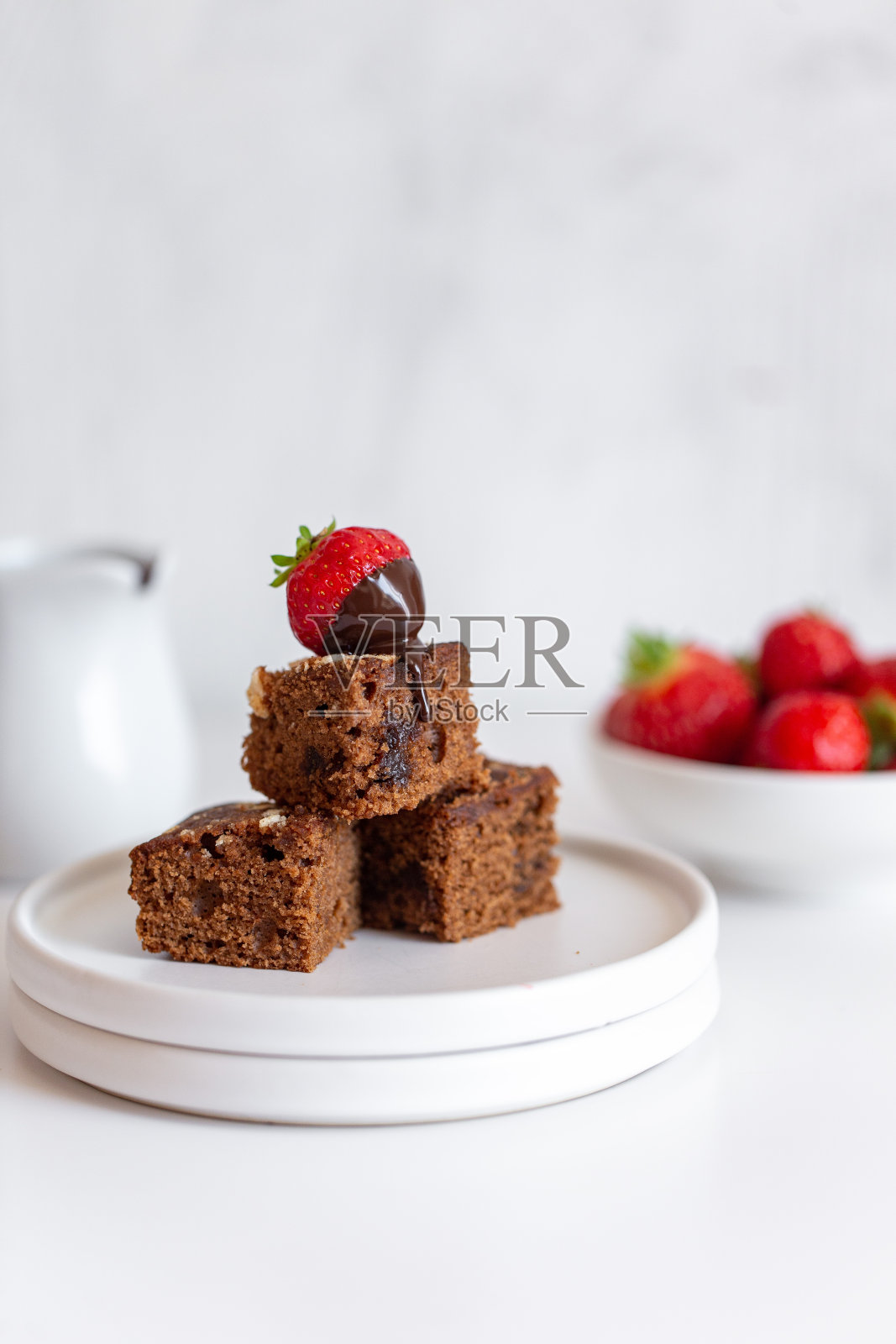 新鲜烘焙美味的巧克力布朗尼，草莓和巧克力酱在白色大理石背景照片摄影图片
