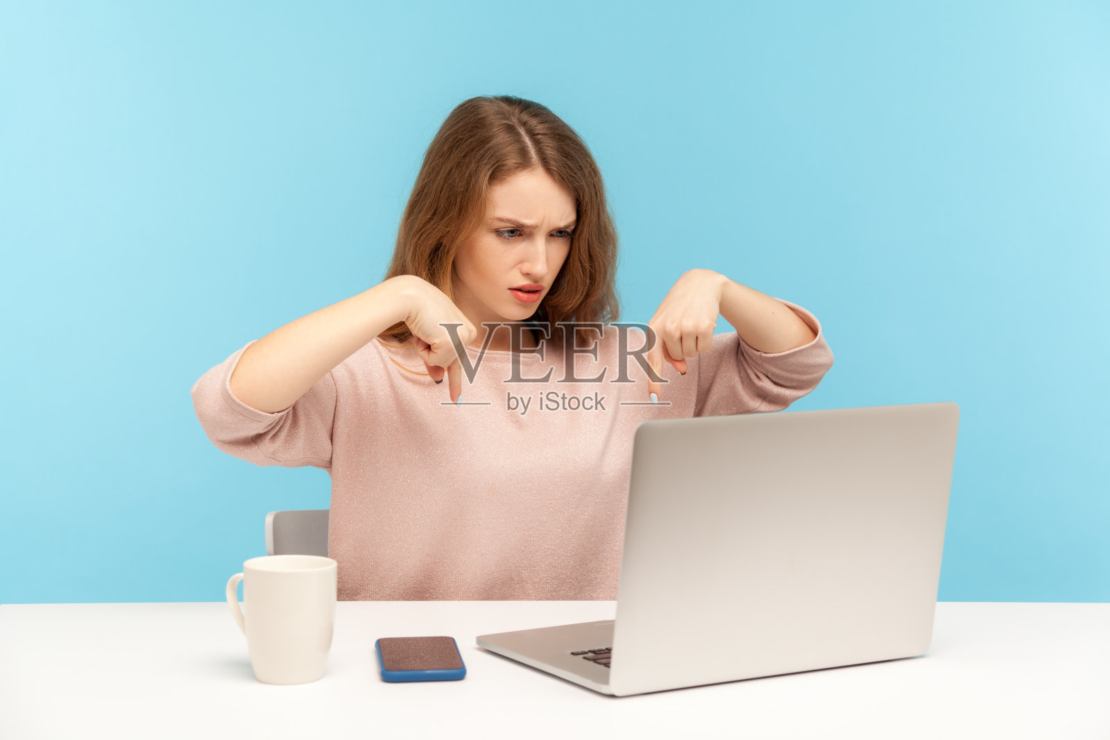此时此地!严厉愤怒的女老板一边用笔记本电脑进行视频通话一边指着手指，控制着照片摄影图片