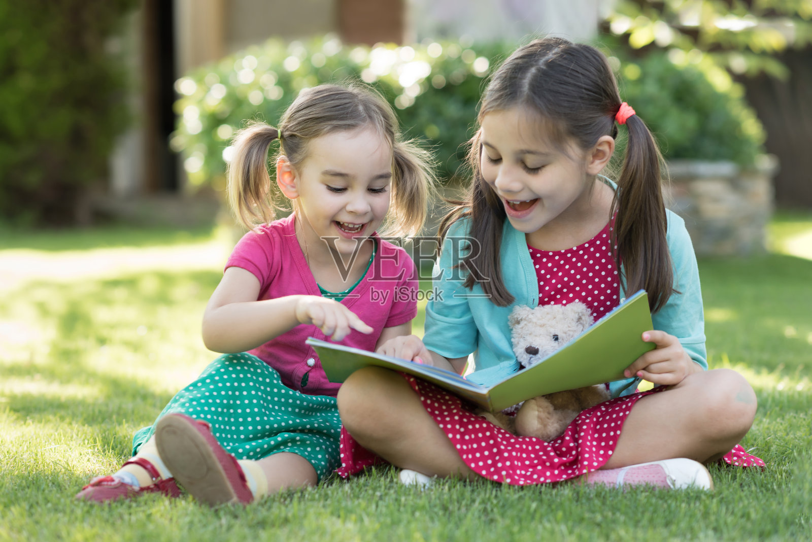 快乐的孩子们一起在夏天的花园里户外读书照片摄影图片