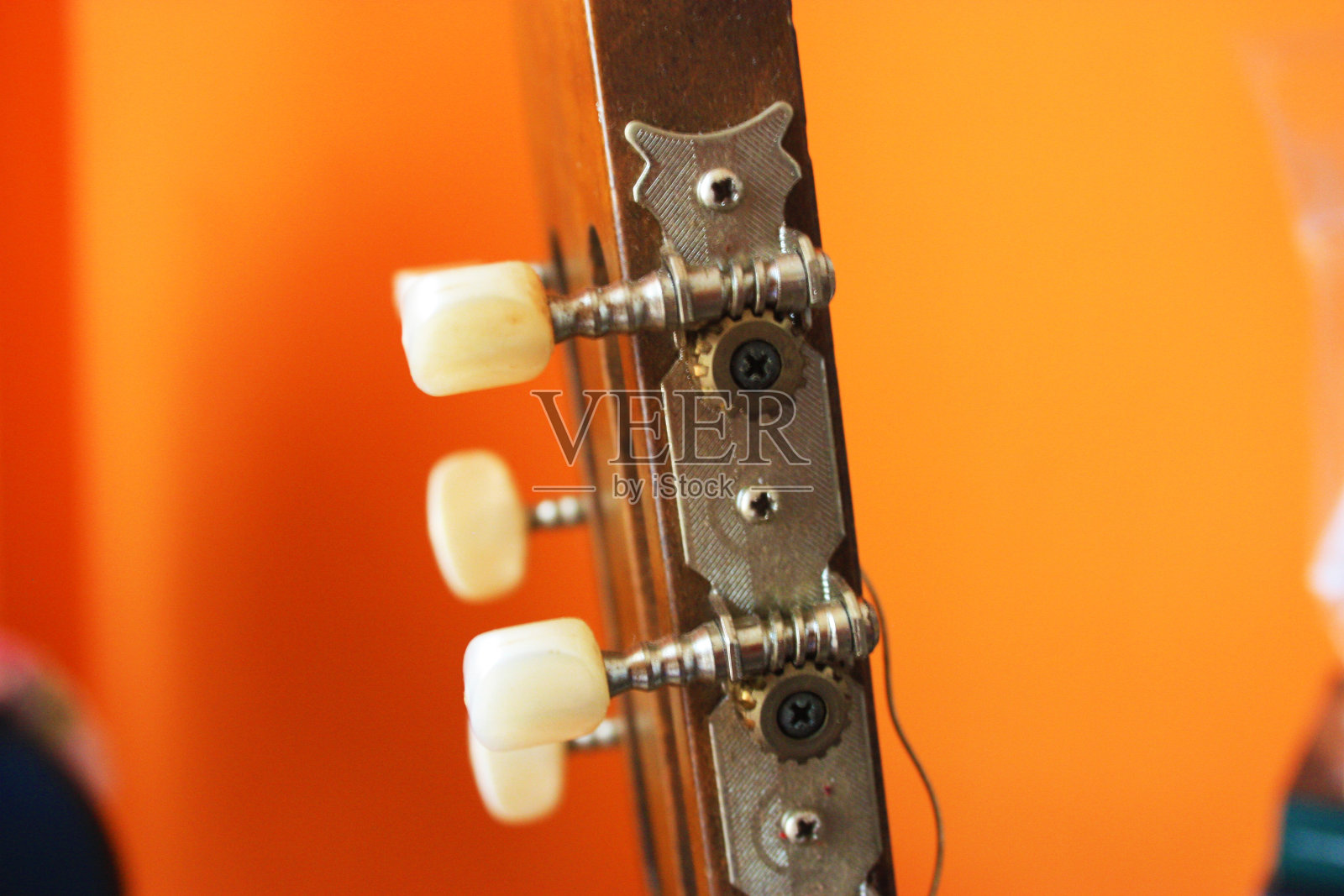 床头箱与机制的古典吉他与明亮的橙色背景照片摄影图片