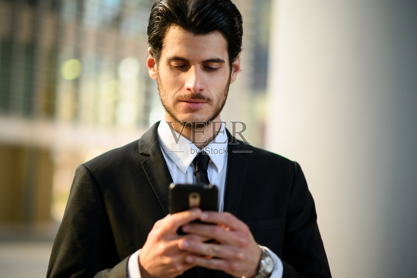 年轻帅气的经理在室外使用智能手机照片摄影图片