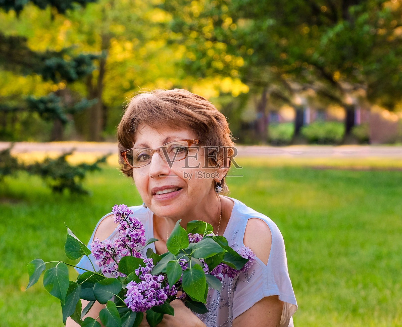 老妇人捧着一束春天盛开的鲜花照片摄影图片