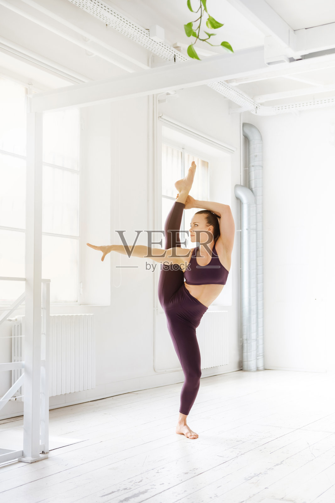 柔顺健康的女人做垂直分裂瑜伽姿势照片摄影图片
