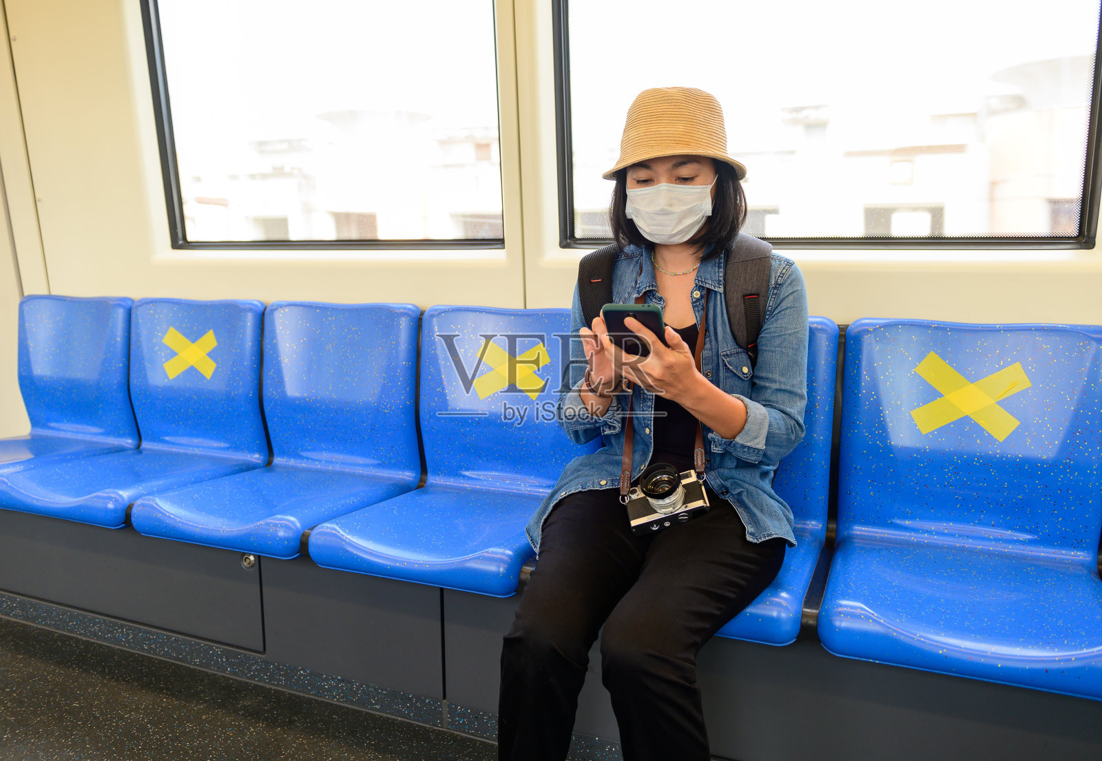 新冠肺炎期间，坐在空中列车上的亚洲女性与他人保持社交距离照片摄影图片