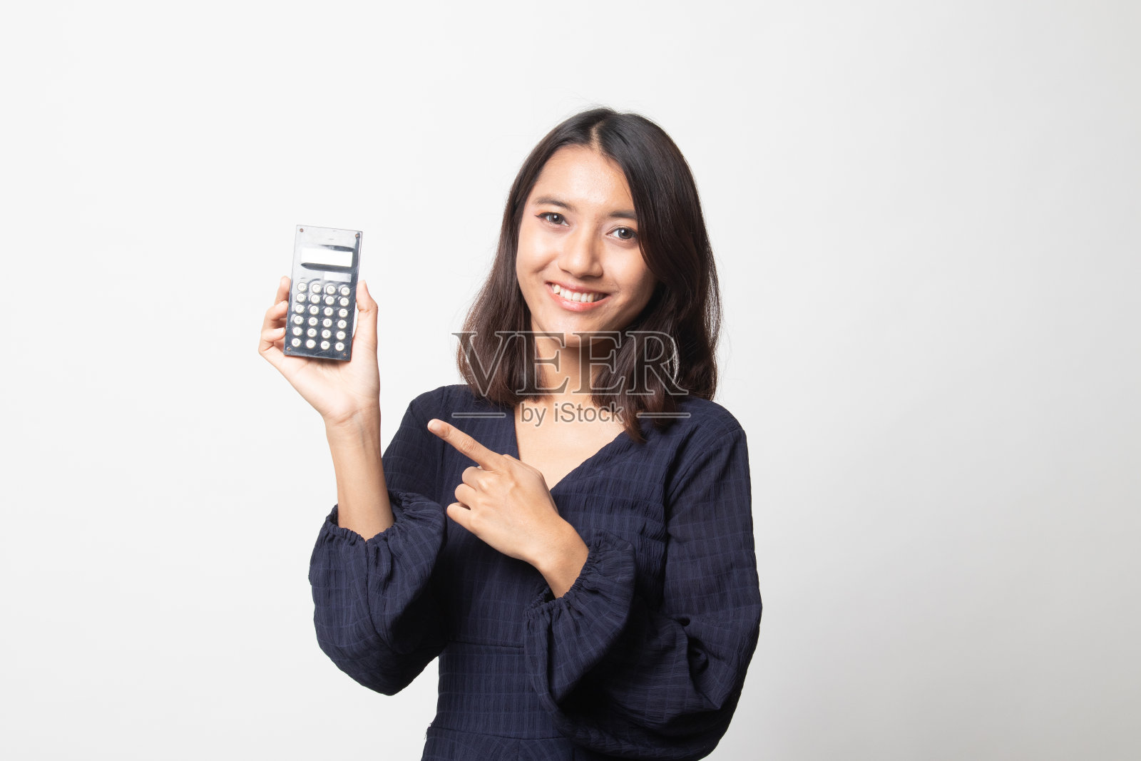亚洲女子指着计算器。照片摄影图片