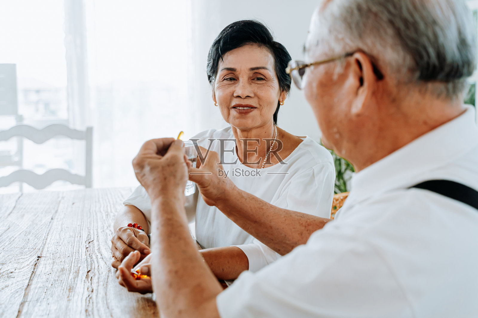 年老的亚洲夫妇在吃药照片摄影图片