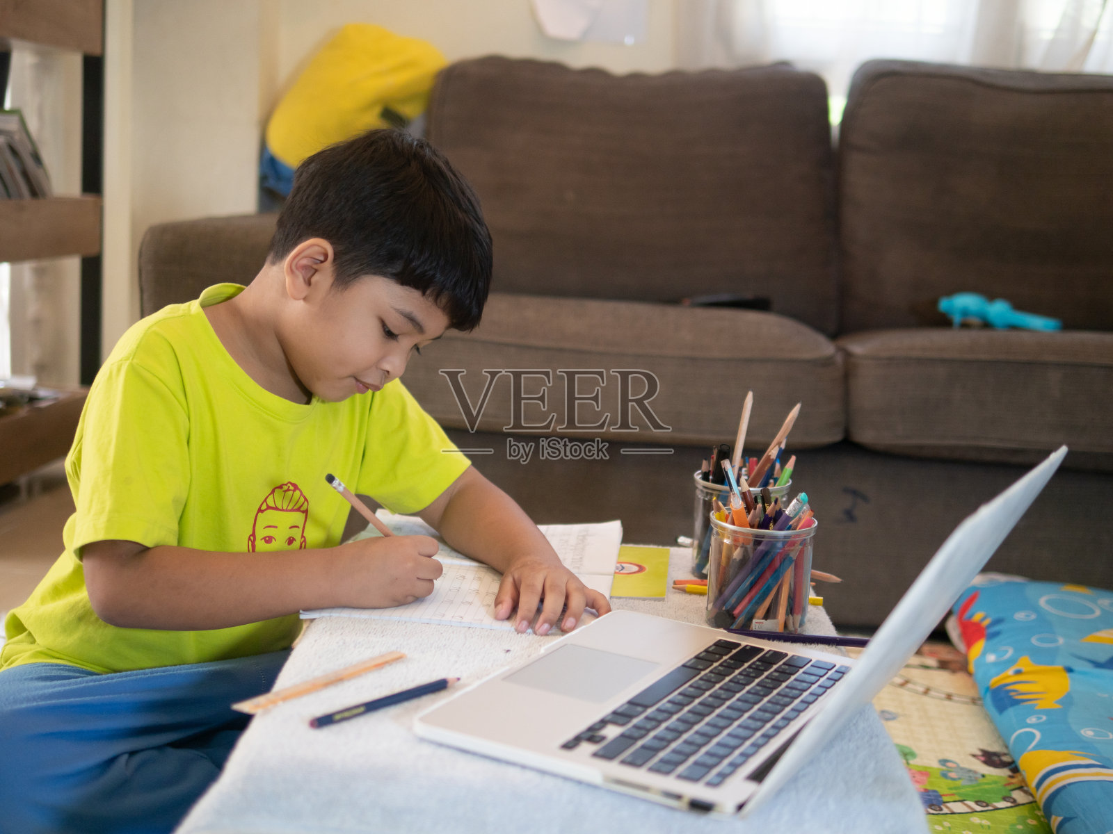亚洲男孩在家在线学习。在2020年全球流行的Covid-19疫情严重爆发期间照片摄影图片