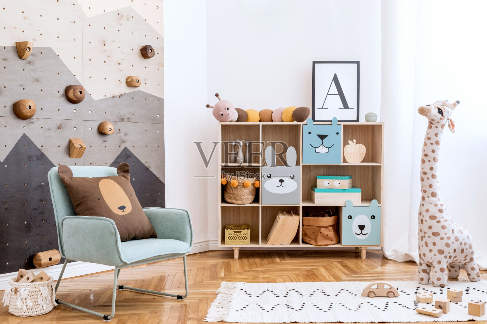 斯堪的纳维亚室内设计的游戏室，现代的儿童攀岩墙，设计家具，薄荷扶手椅，毛绒玩具，泰迪熊和可爱的儿童配件。模拟海报框架。模板。照片摄影图片