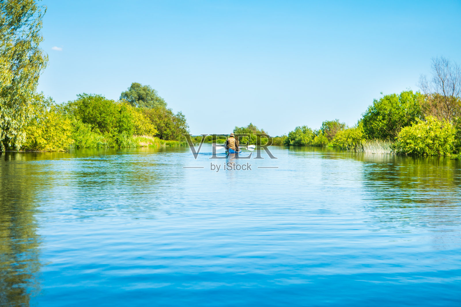 一对夫妇在蓝色河流景观的皮划艇之旅照片摄影图片
