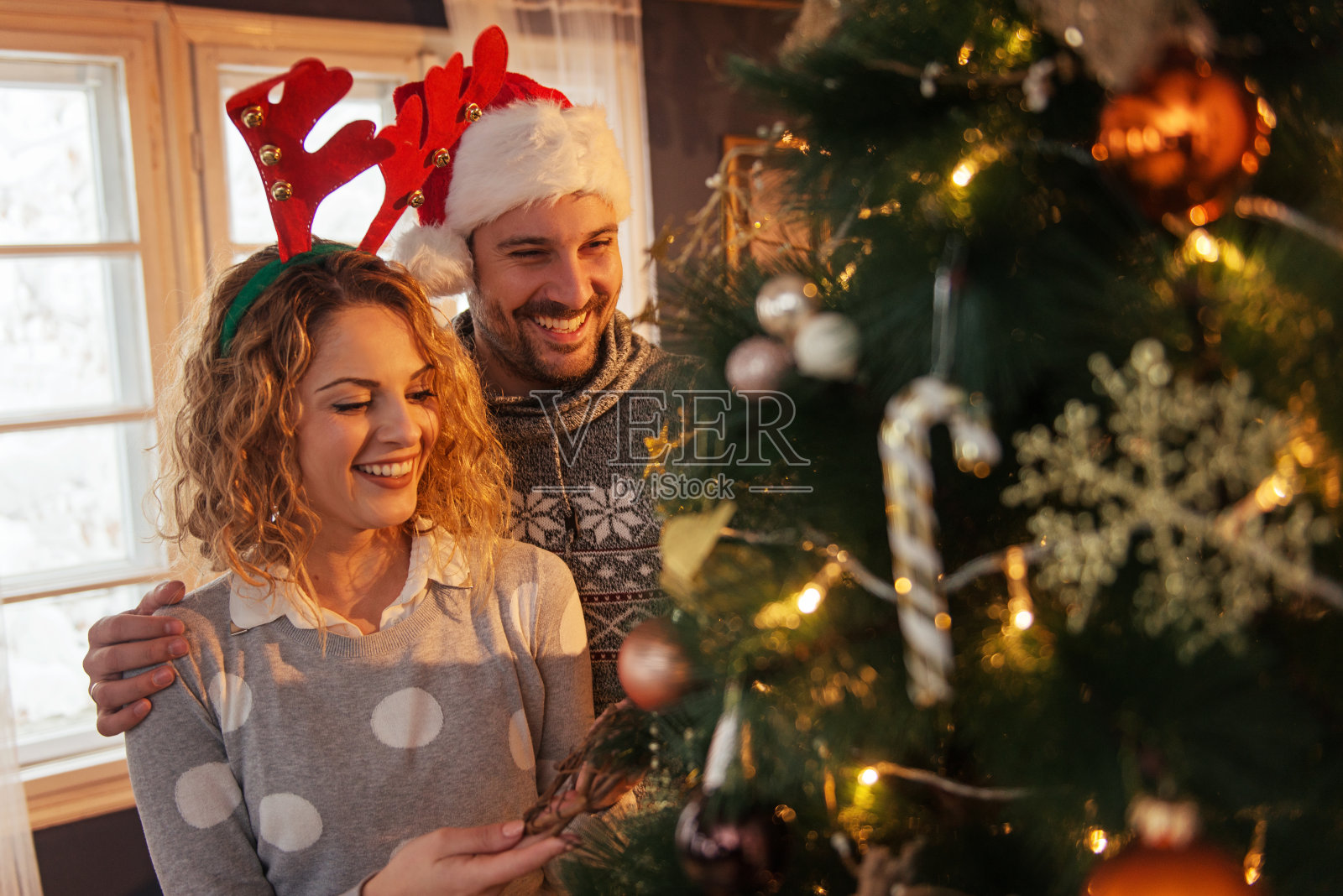 可爱的夫妇装饰圣诞树照片摄影图片