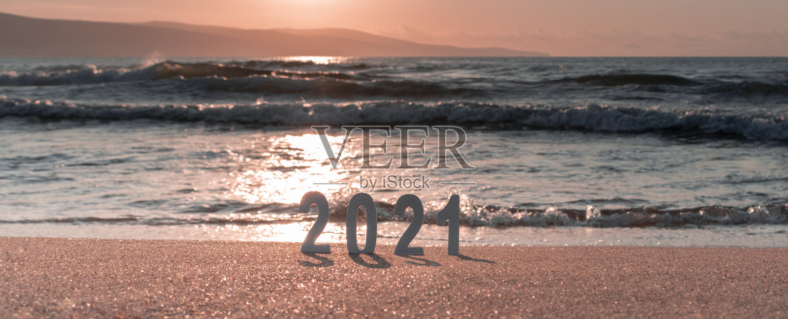 数字2021在美丽的海洋日落的自然模糊背景。新年的愿景，梦想，目标理念。在海滩上庆祝新年快乐。横幅，选择性焦点，复制空间照片摄影图片