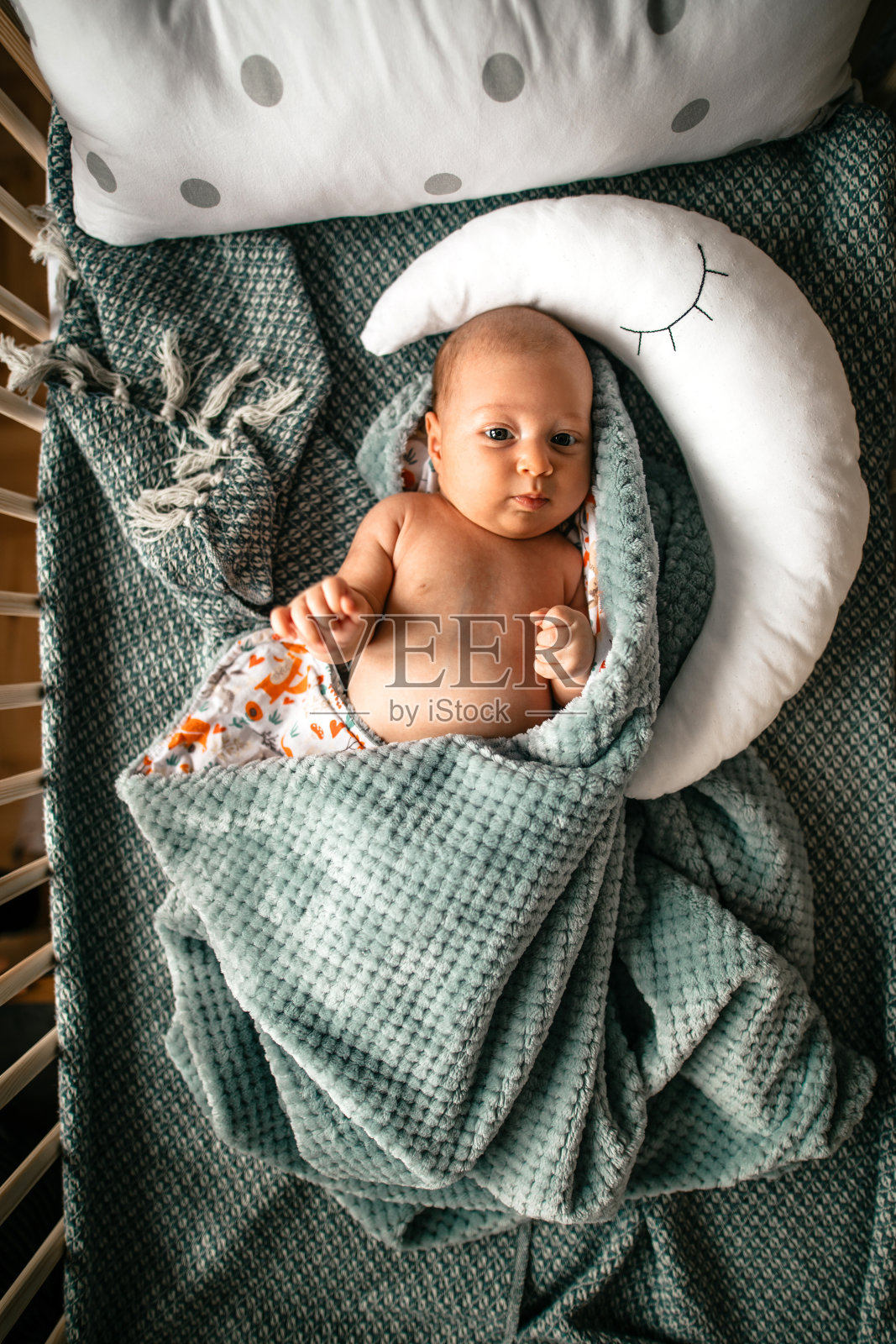 可爱的新生婴儿躺在婴儿床上照片摄影图片
