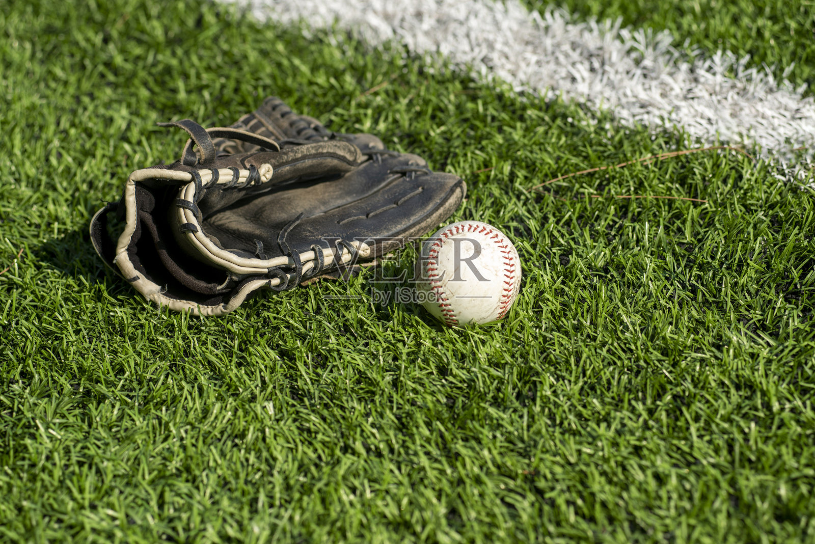 棒球手套和草地上的球照片摄影图片