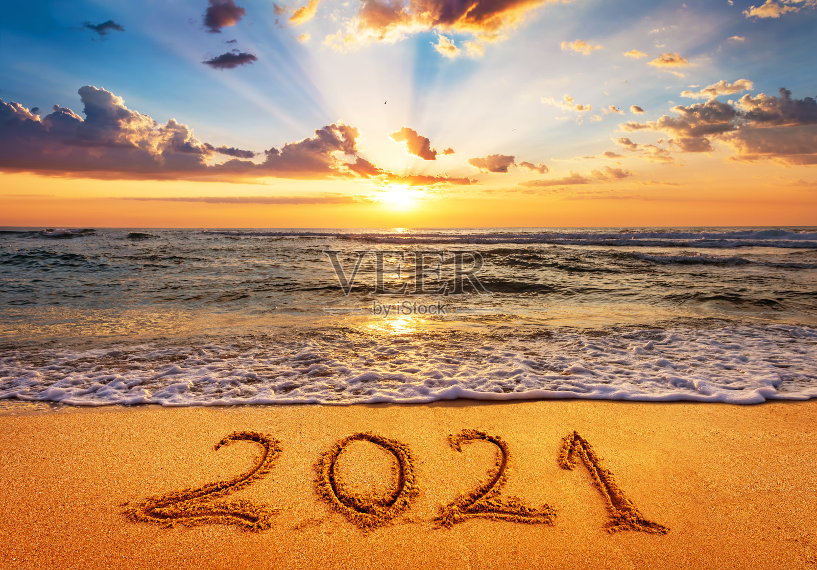 2021年新年快乐即将到来。日出时写在沙滩上的2021号。照片摄影图片
