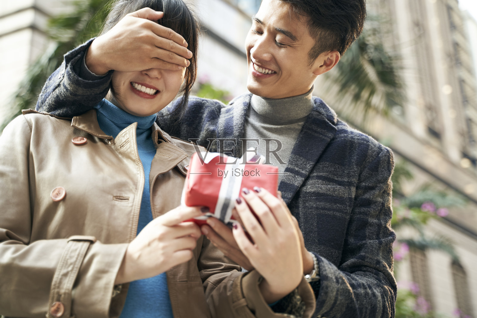 年轻的亚洲男人在户外给女朋友一个惊喜的礼物照片摄影图片